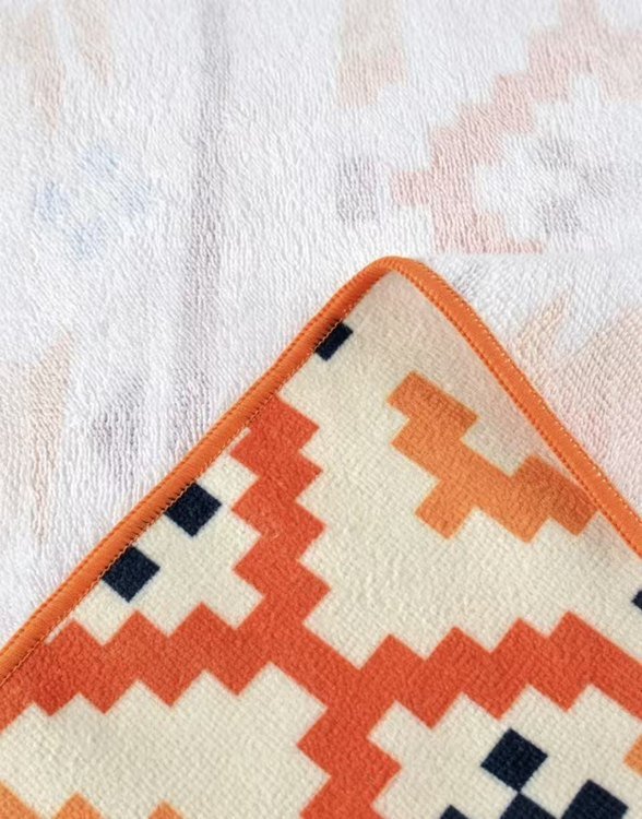 Orange patterned towel with a microfiber print face and cotton terry reverse
