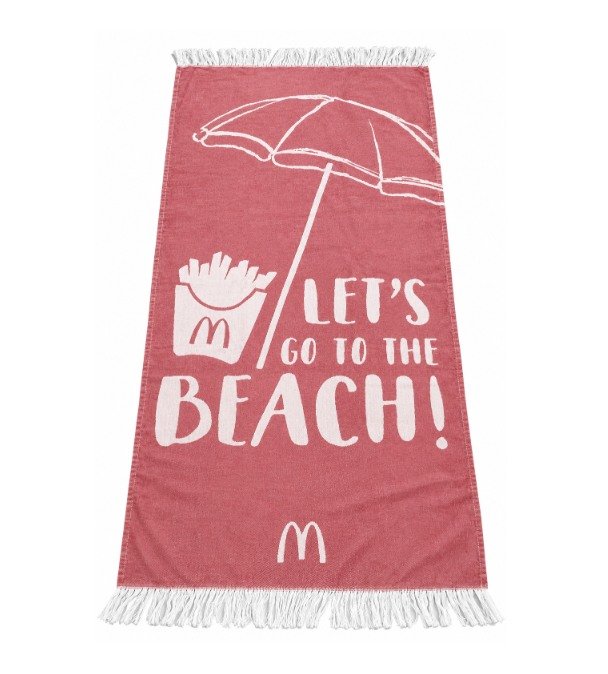 Red fringed Turkish towel with white beach-themed artwork on a white background