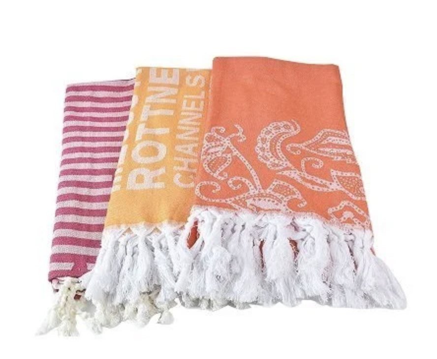 Folded pink, yellow and orange Turkish towels with white fringes
